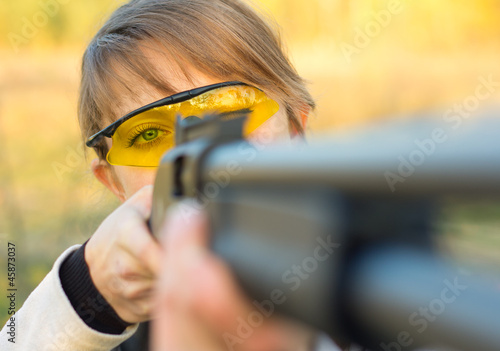 Young beautiful girl with a shotgun photo