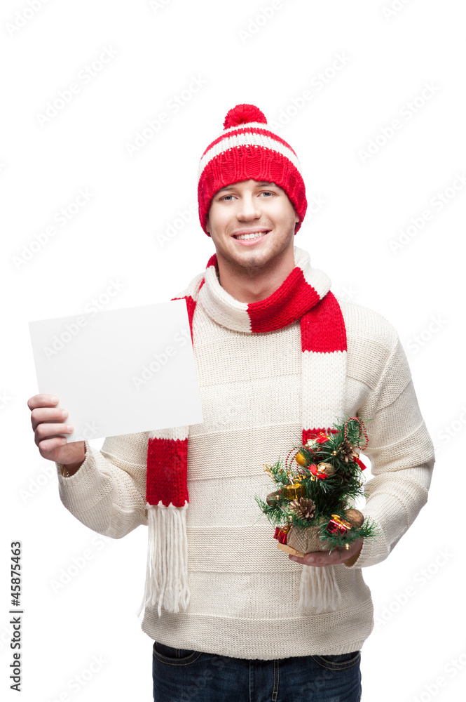 young man holding small christmas tree and sign young man holding small christmas tree and sign