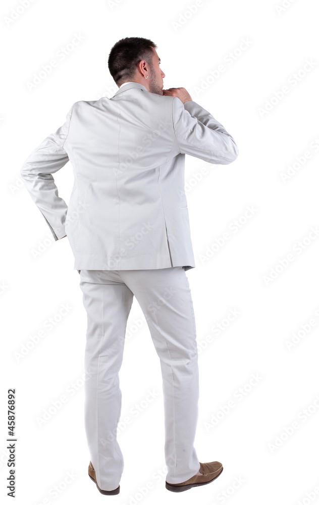 Back view of thinking young business man in white suit. Back view of thinking young business man in white suit.