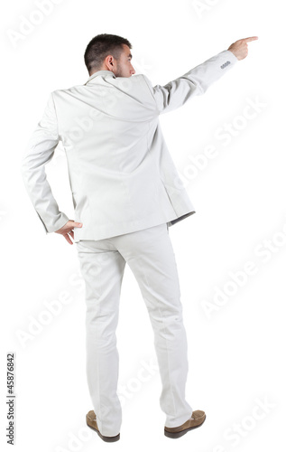 Back view of businessman pointing at wall.