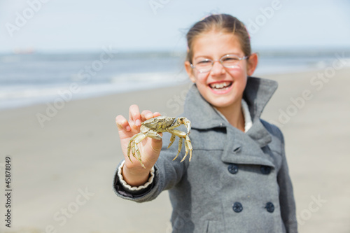 Adorable happy girl holding crab