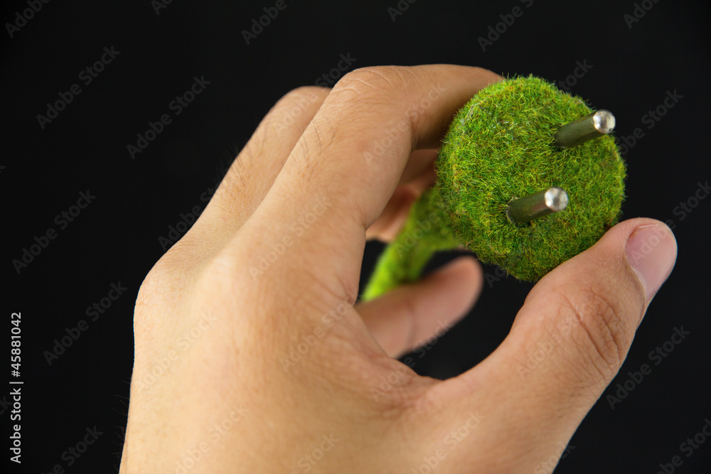 hand holding green electric plug
