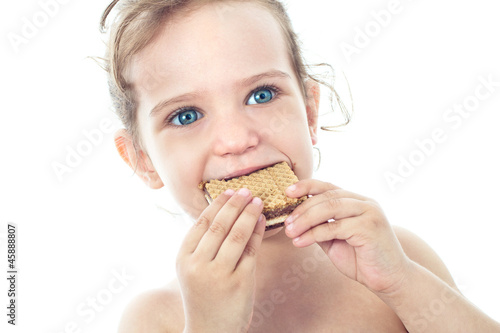 Beautiful sweet  little girl eating a cookie