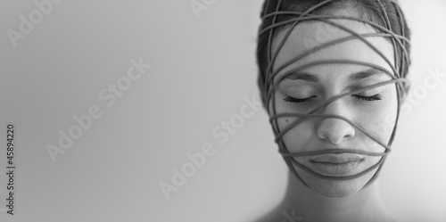 Close up of woman constrained with ropes. Black and white.