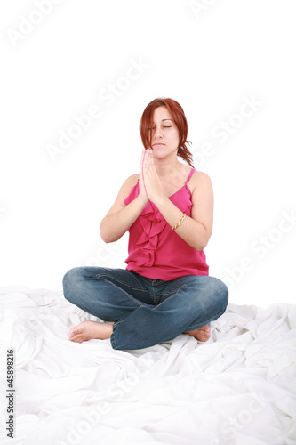 young woman spending yogatic time by herself in the bedroom with photo