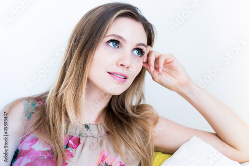 woman holding her face on the couch