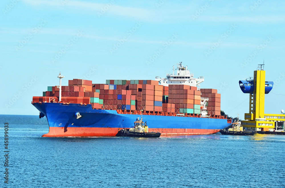 Tugboat assisting container cargo ship to harbor quayside Tugboat assisting container cargo ship to harbor quayside