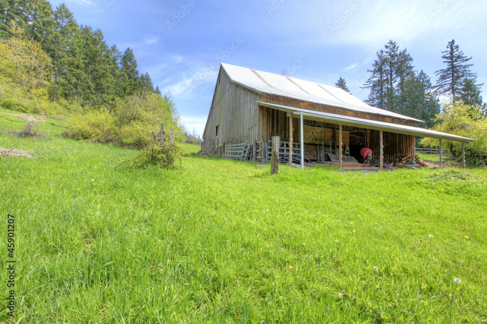 Old large shed with green spring landscape and fence. Old large shed with green spring landscape and fence.