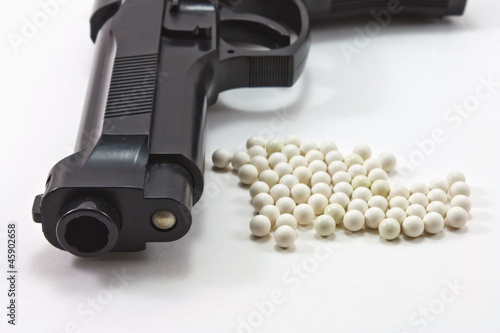 White balls with an black gun (airsoft) isolated on white