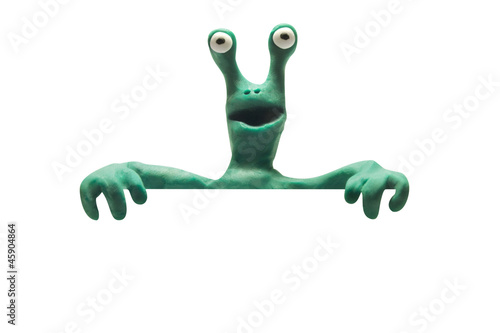 clay alien from behind blank banner