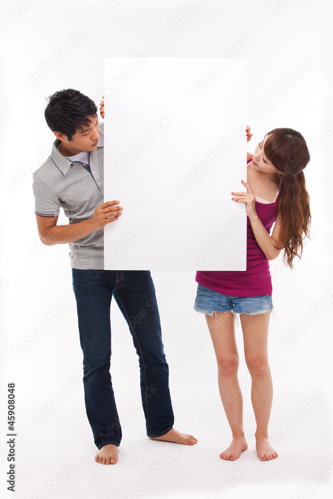 Young couple take white panel isolated on white background. Young couple take white panel isolated on white background.