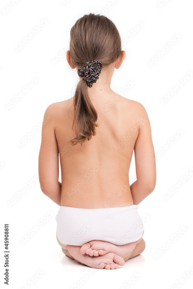 Nude little girl sitting back to us on a light background Stock