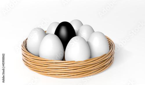 Black egg among white eggs in the basket