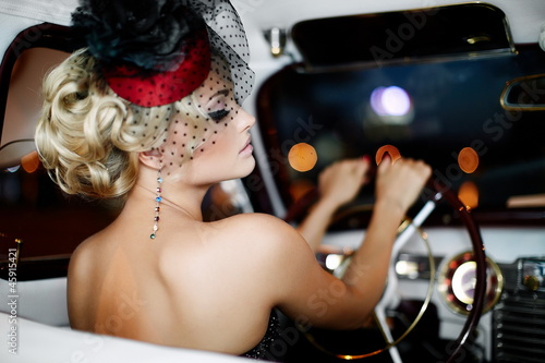 beautiful fashion girl in retro style sitting in old car
