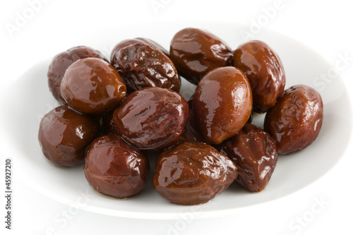 canned prunes on a dish isolated