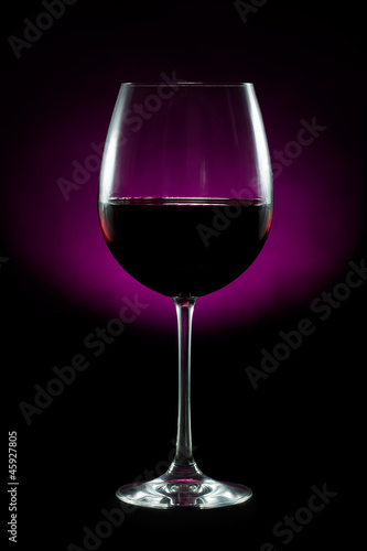Elegant glass of red wine isolated on black background