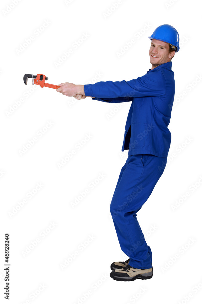Tradesman using a pipe wrench to drag an invisible object Tradesman using a pipe wrench to drag an invisible object