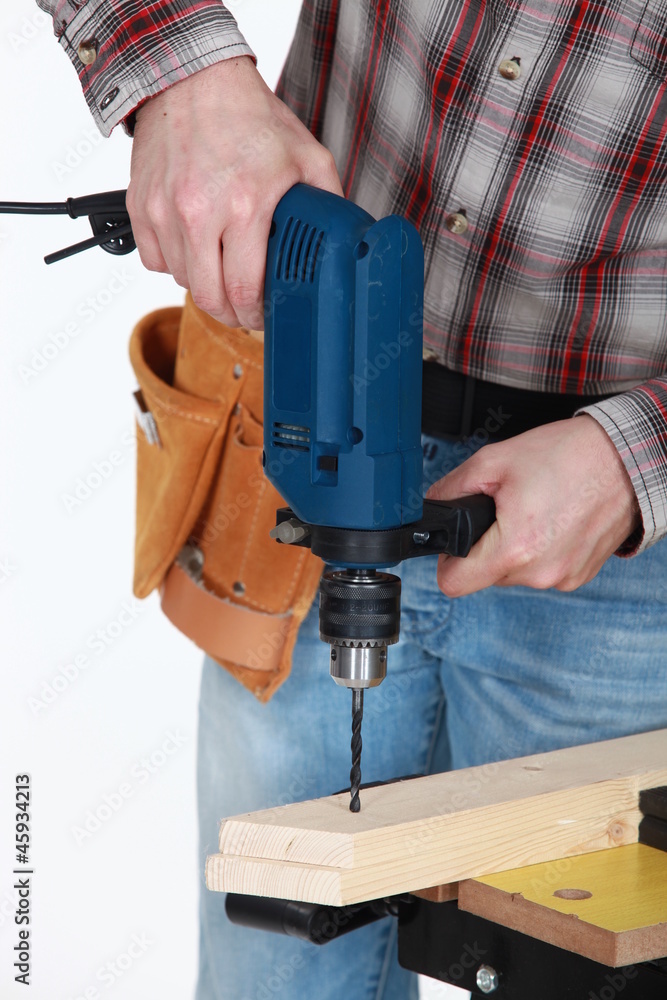 Man drilling through plank of wood