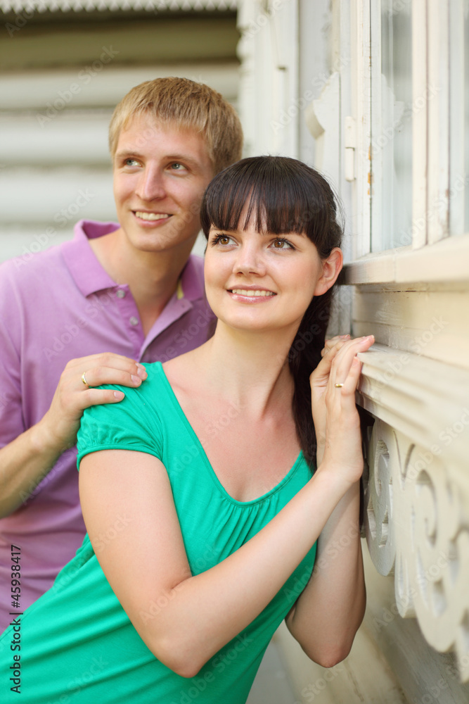 Fototapeta premium Husband hug wife near wooden village house