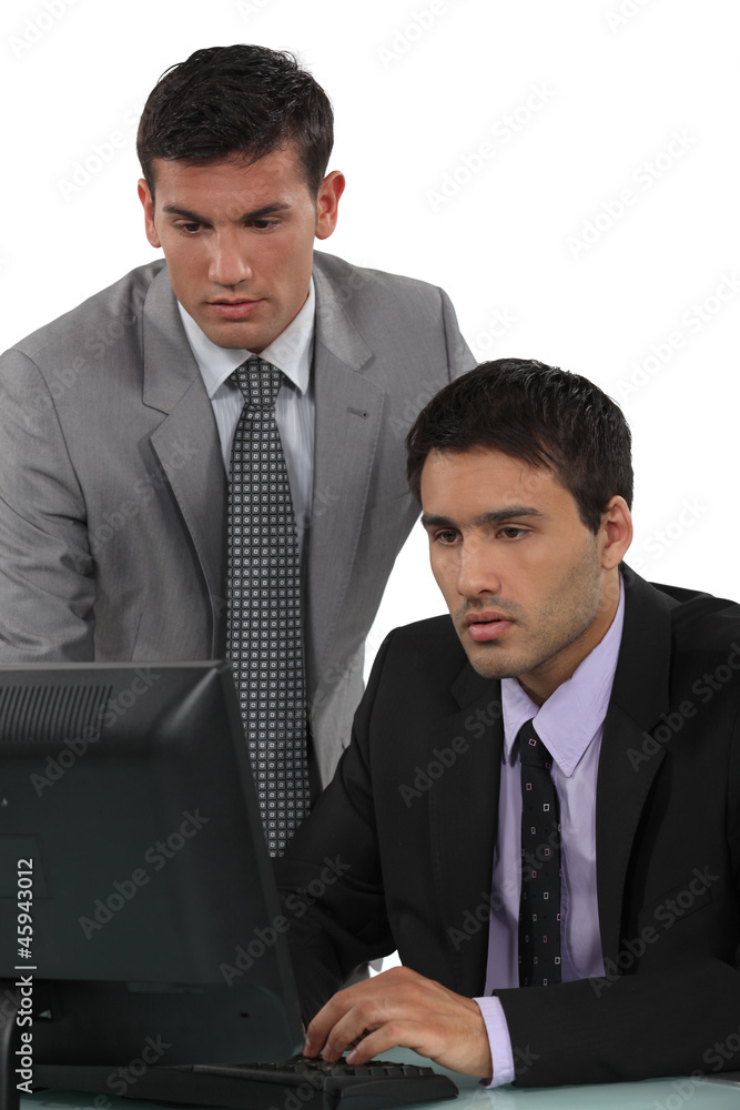 Two businessmen preparing presentation on computer Two businessmen preparing presentation on computer