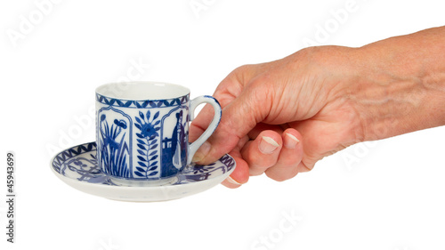 Old lady (hand) with an antique Dutch cup in Delfts blue, Hollan photo