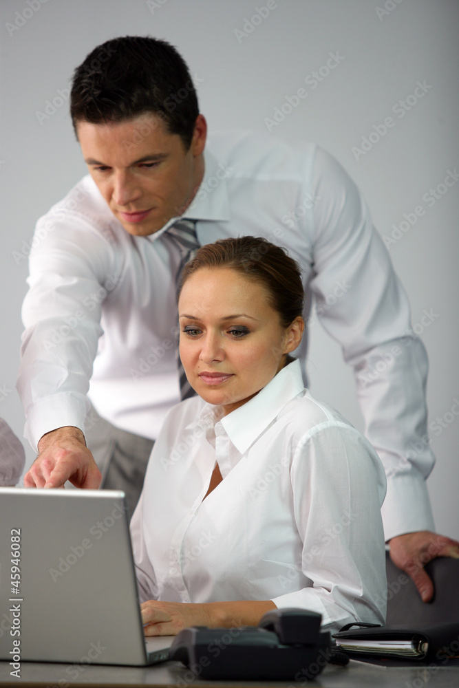 Man explaining something to woman on laptop Man explaining something to woman on laptop