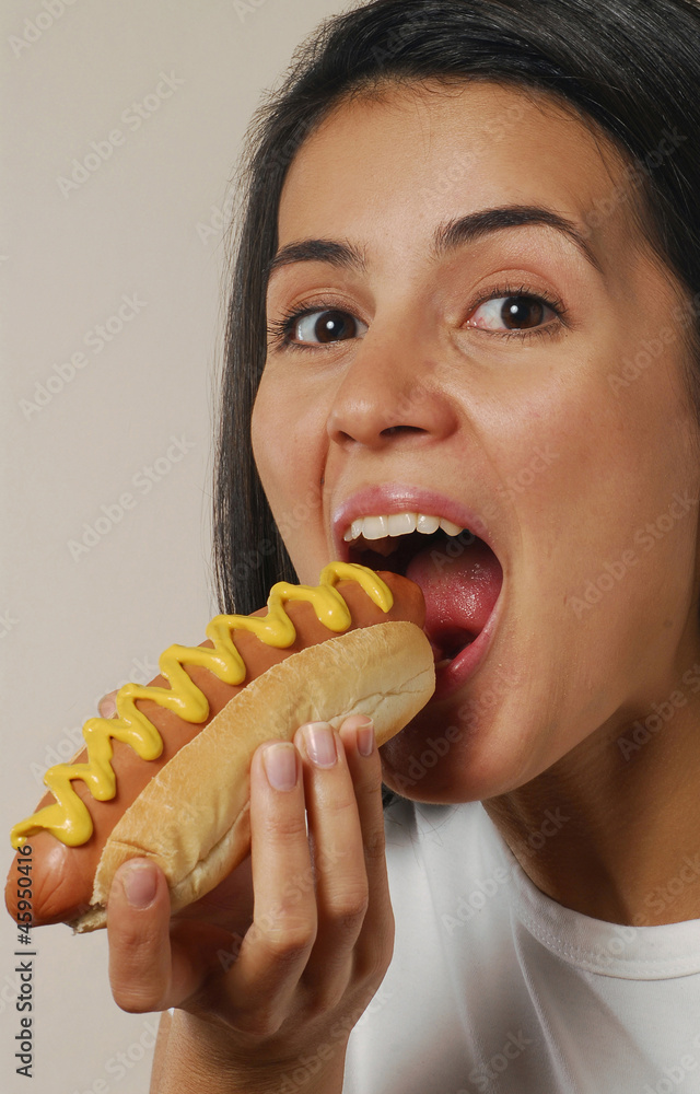 Mujer comiendo perro caliente,comida rápida. Mujer comiendo perro caliente,comida rápida.