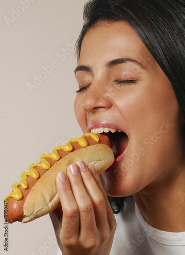 Mujer comiendo perro caliente,comida rápida. photo
