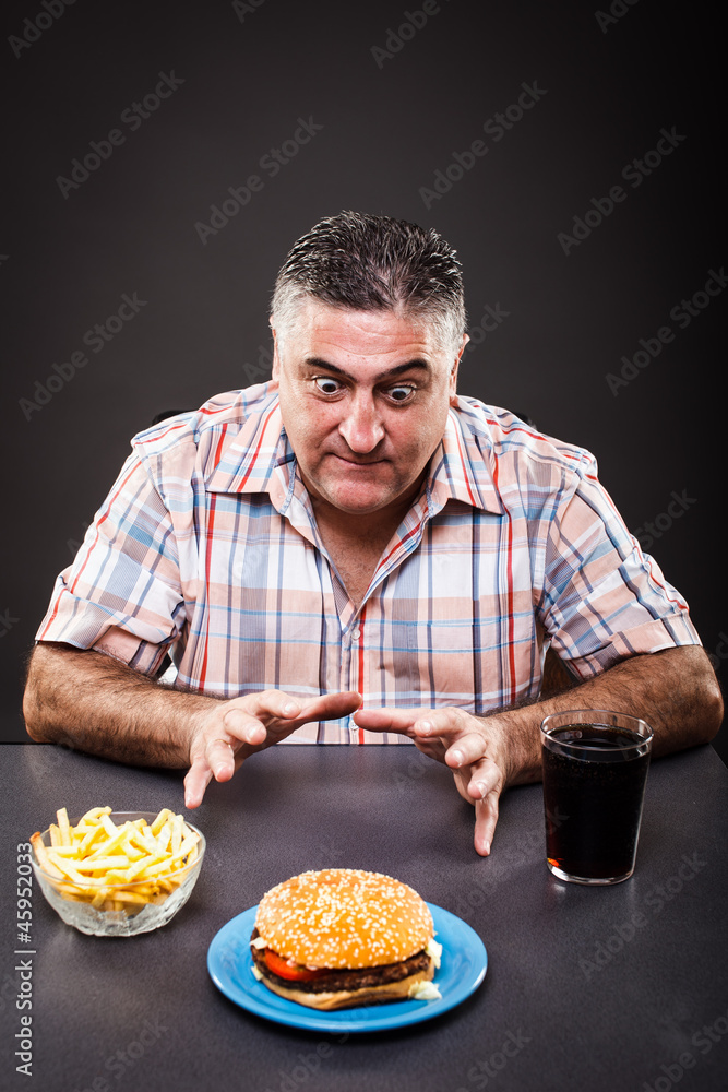 Greedy man looking at burger Greedy man looking at burger