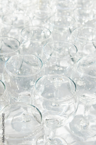 Many transparent glasses stand on the table