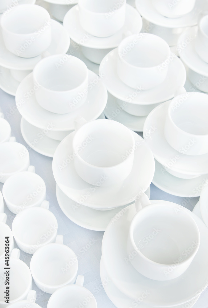 White cups stand in a line on a table White cups stand in a line on a table