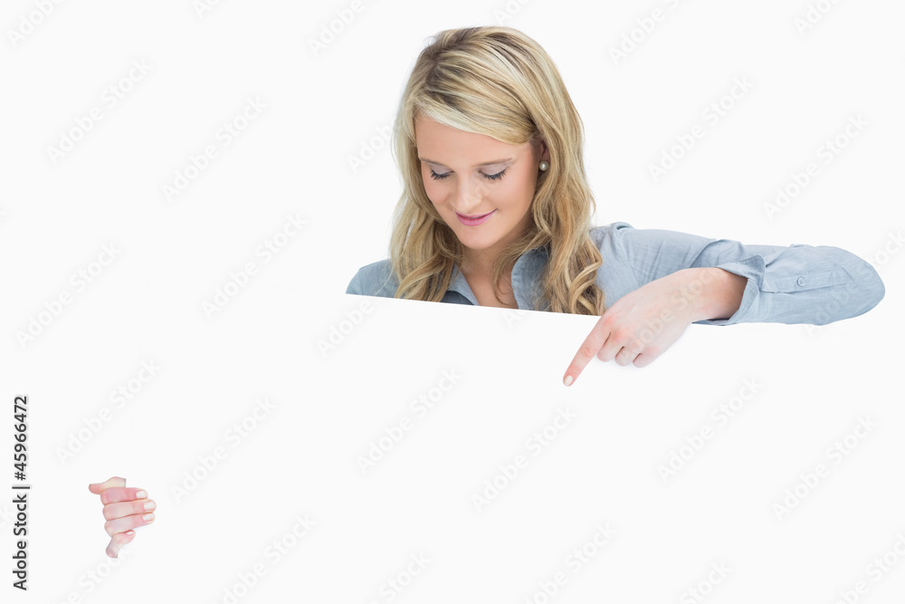 Smiling woman pointing on the poster Smiling woman pointing on the poster