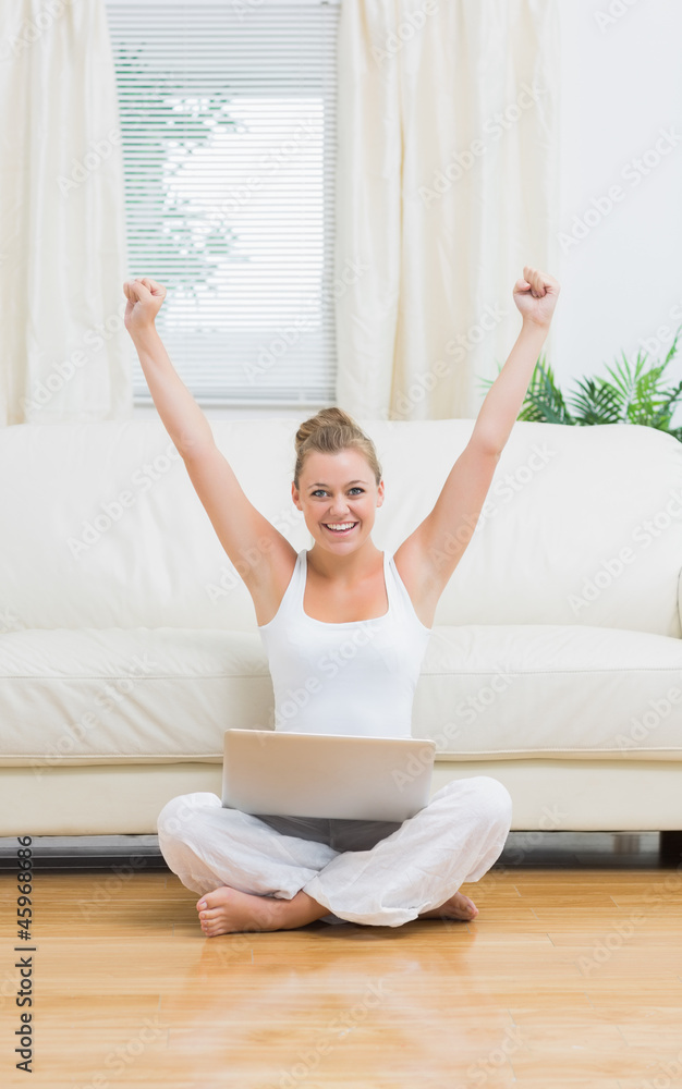 Cheerful woman raising hands while using laptop Cheerful woman raising hands while using laptop