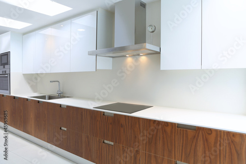 Actual modern kitchen in white and walnut wood
