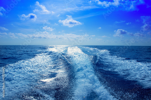 Obraz na plátně Boat wake prop wash foam in blue sky