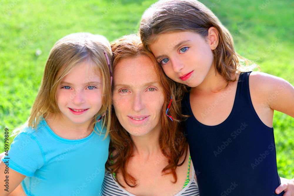 Obraz premium mother and two sister daughters in the garden