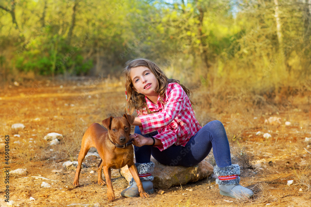 girl sitting in the pine forest holding little dog girl sitting in the pine forest holding little dog