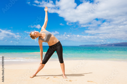 Attractive Young Woman Stretching at the Beach 