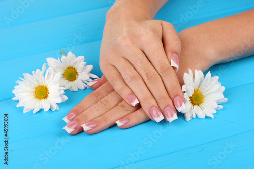 Woman hands with french manicure and flowers