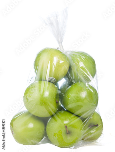 Green apple in plastic bag on white background