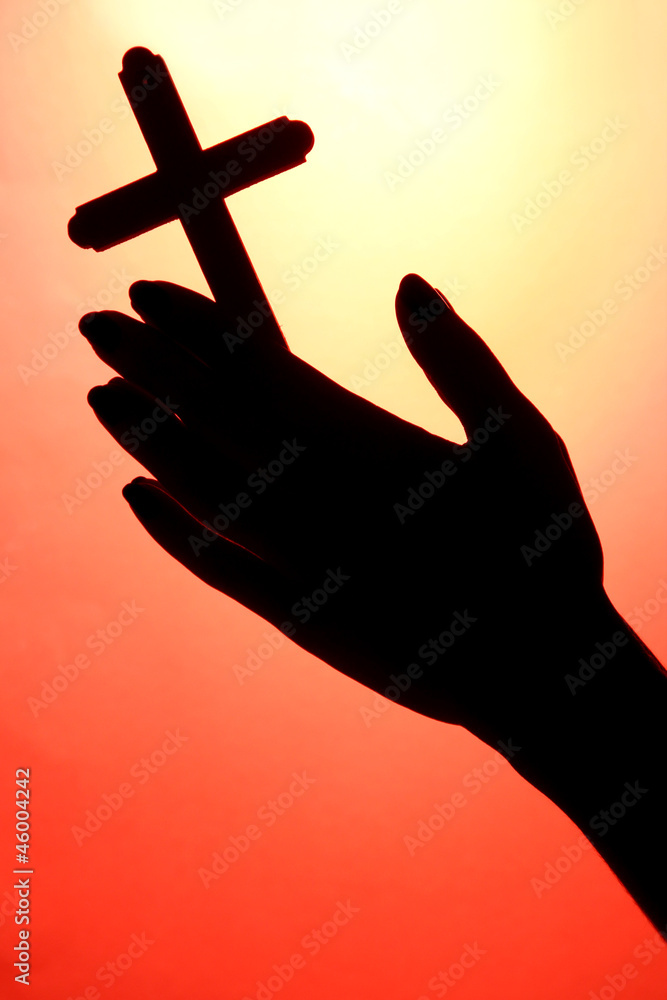 female hands with crucifix, on red background female hands with crucifix, on red background