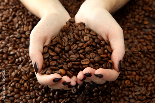female hands with coffee beans  close up