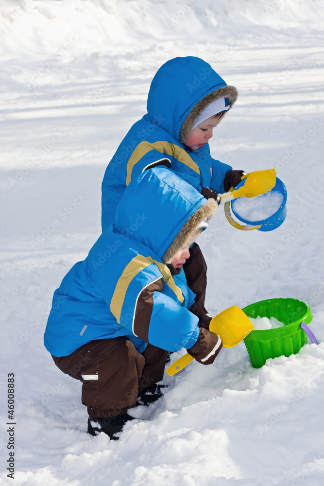 One-year-old twins play in snow