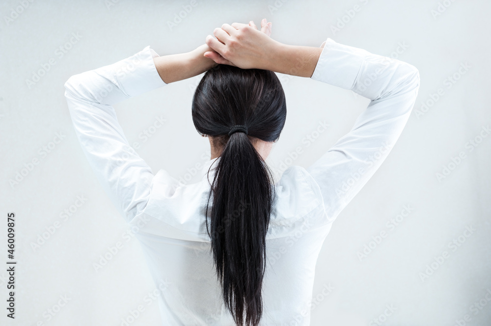 Fototapeta premium Rear view of young business woman with hands behind head