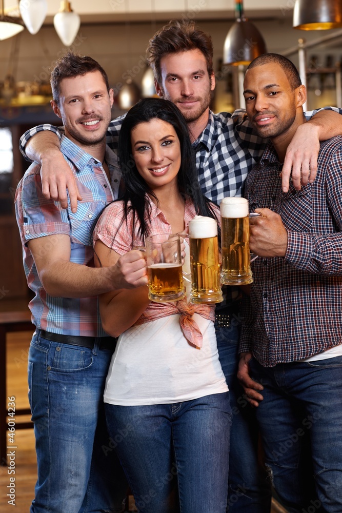 Group of happy friends drinking beer at pub