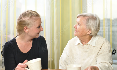 Obraz na płótnie Senior woman with her granddaughter talk to each other. w salonie