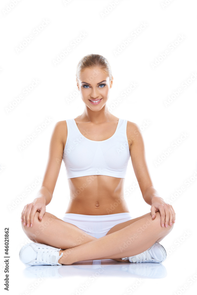 Happy young woman sitting with legs crossed on isolated Happy young woman sitting with legs crossed on isolated