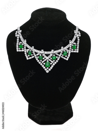 Pendant with green gem stones on black mannequin isolated on whi