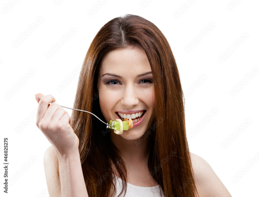 Woman eating green salad on the stainless fork Woman eating green salad on the stainless fork