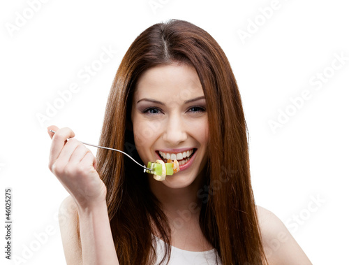 Woman eating green salad on the stainless fork
